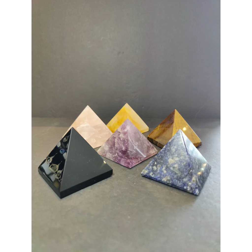 Five crystal polished pyramid sculptures in assorted stones with black, pink beige, yellow, purple, and blue hues