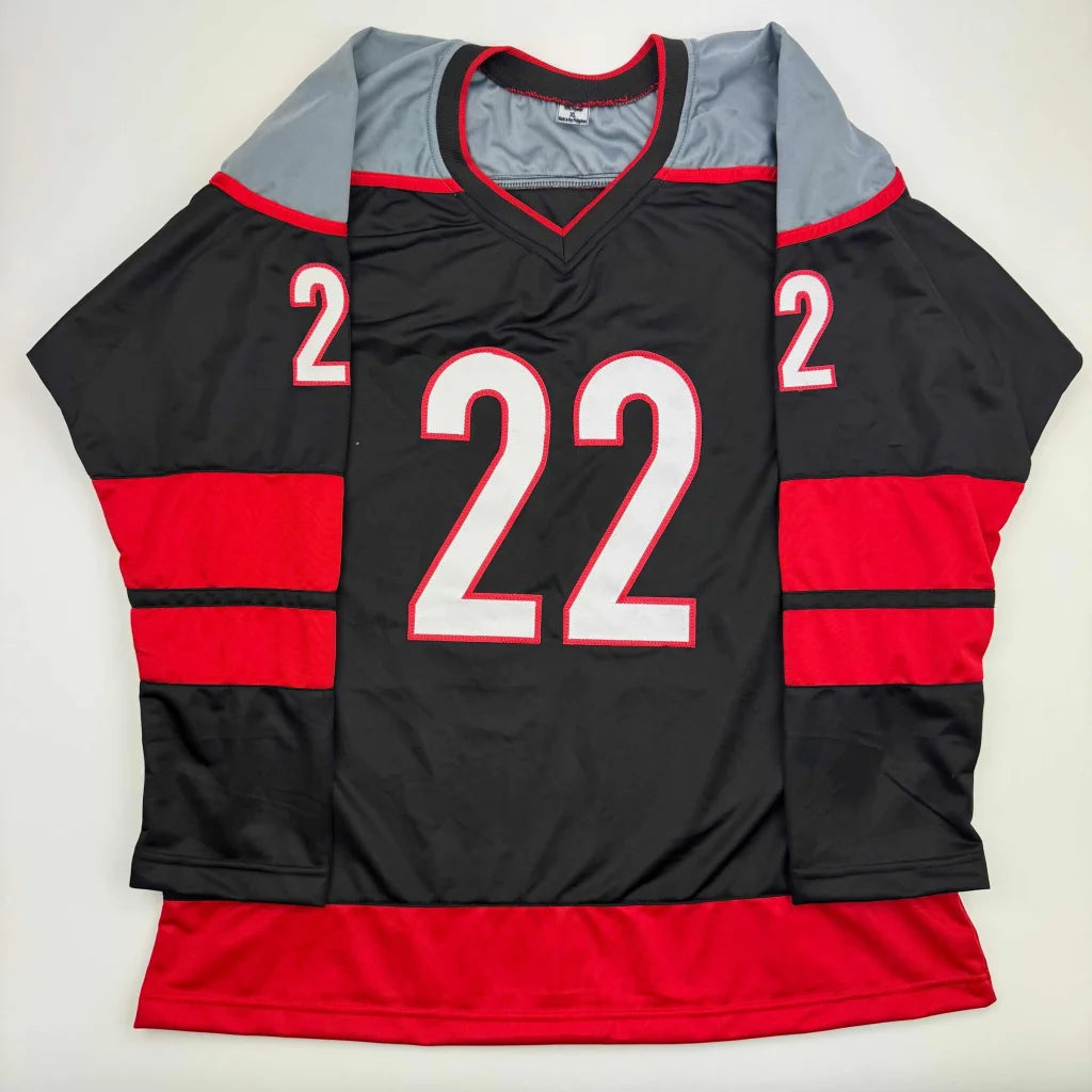 Black custom hockey jersey with red and gray accents and number 22 from professional sports league
