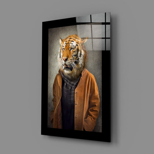 Angled view of framed glass wall art depicting a tiger-headed figure wearing an orange jacket over dark shirt, mounted on gray wall.