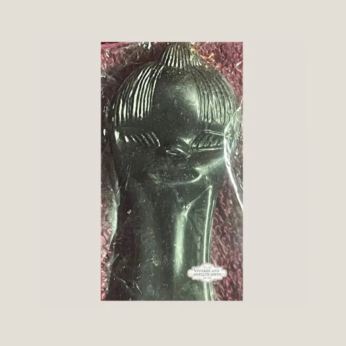 Dark metallic sculpture with ribbed dome atop 1960s Vintage Comb Brush Combo Gift Gem