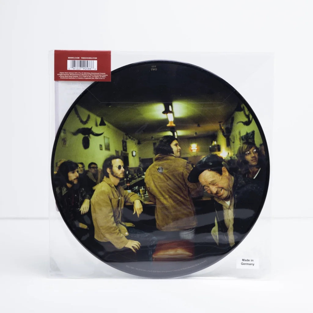 Picture disc vinyl of The Doors Morrison Hotel 50th Anniversary in a dimly lit bar setting