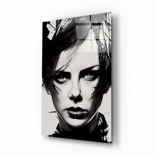Black and white portrait on glass wall art showing a person with short dark hair and dramatic makeup, displayed at an angle against white background.