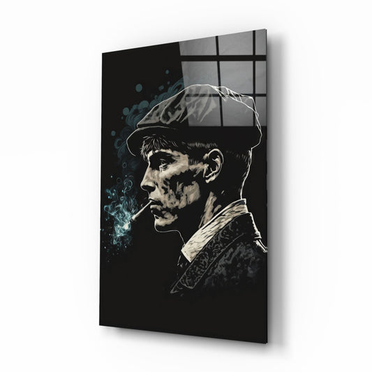 Profile view of monochromatic glass wall art depicting a man in newsboy cap and jacket smoking cigarette, with blue smoke effects on black background.