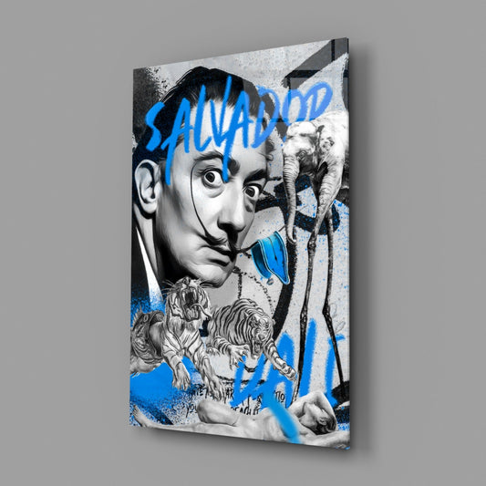 Angled view of glass wall art featuring a surrealist portrait with blue "SALVADO" text, elephants, tigers, and decorative elements in black and white with blue accents.