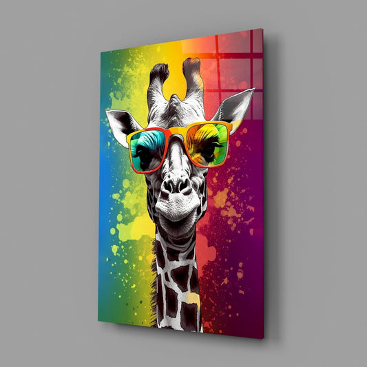 Angled perspective view of glass wall art featuring a giraffe wearing rainbow-tinted sunglasses against a colorful splattered background in greens, yellows, reds, and purples.
