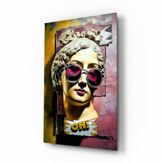 Three-quarter angled view of glass wall art featuring classical bust with pink sunglasses, gold face, and "OH!" comic text on pink and yellow background.