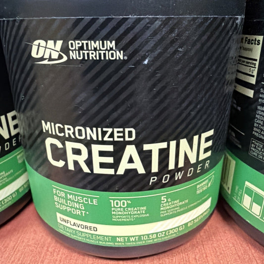 Close-up of black and green Optimum Nutrition Micronized Creatine Powder container front label showing product name and specifications.