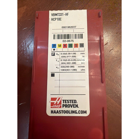 Red plastic case with white Haas tool label displaying VBMT331-HF specifications and barcode.