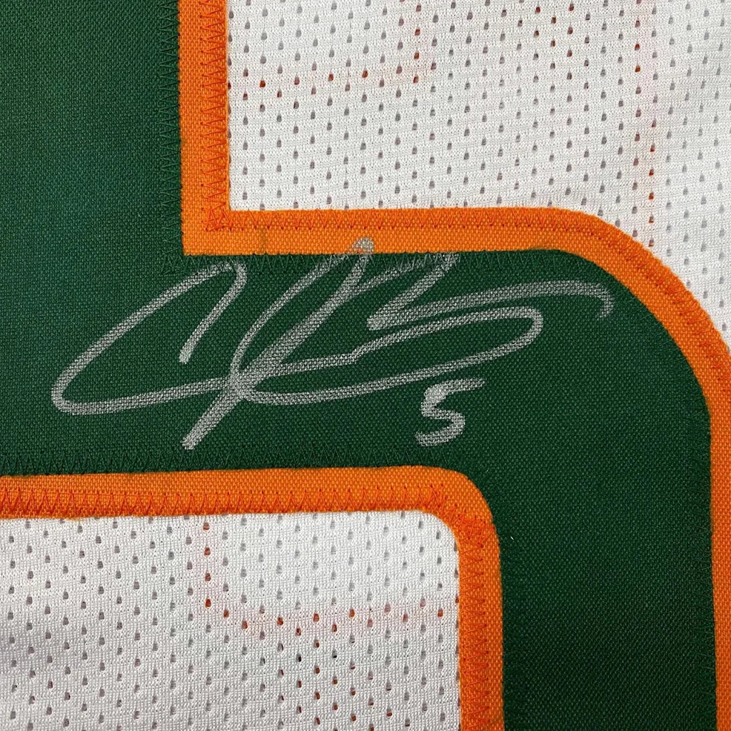 Green and white Miami Hurricanes jersey with orange trim, silver autograph, and number 5