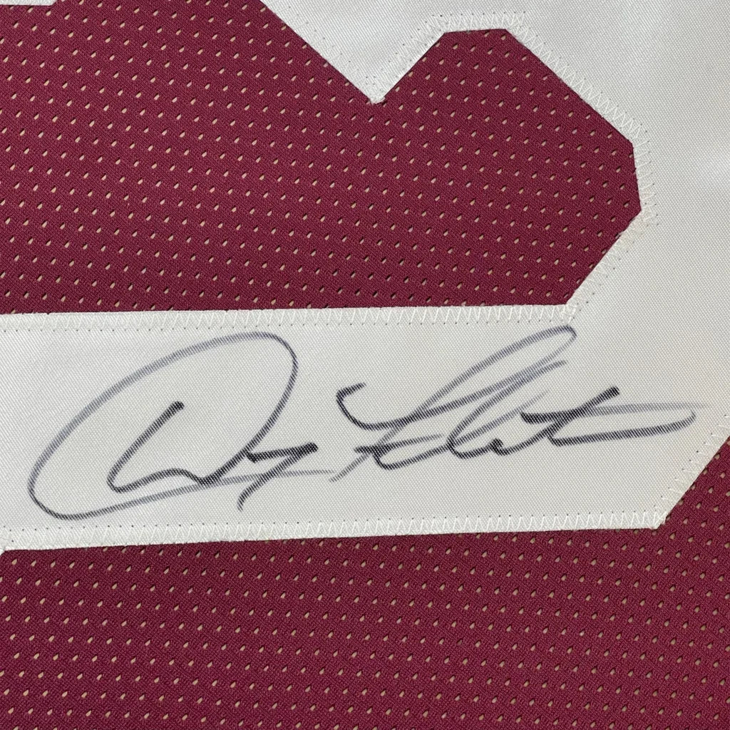 Maroon sports jersey with a white number and a black autograph.