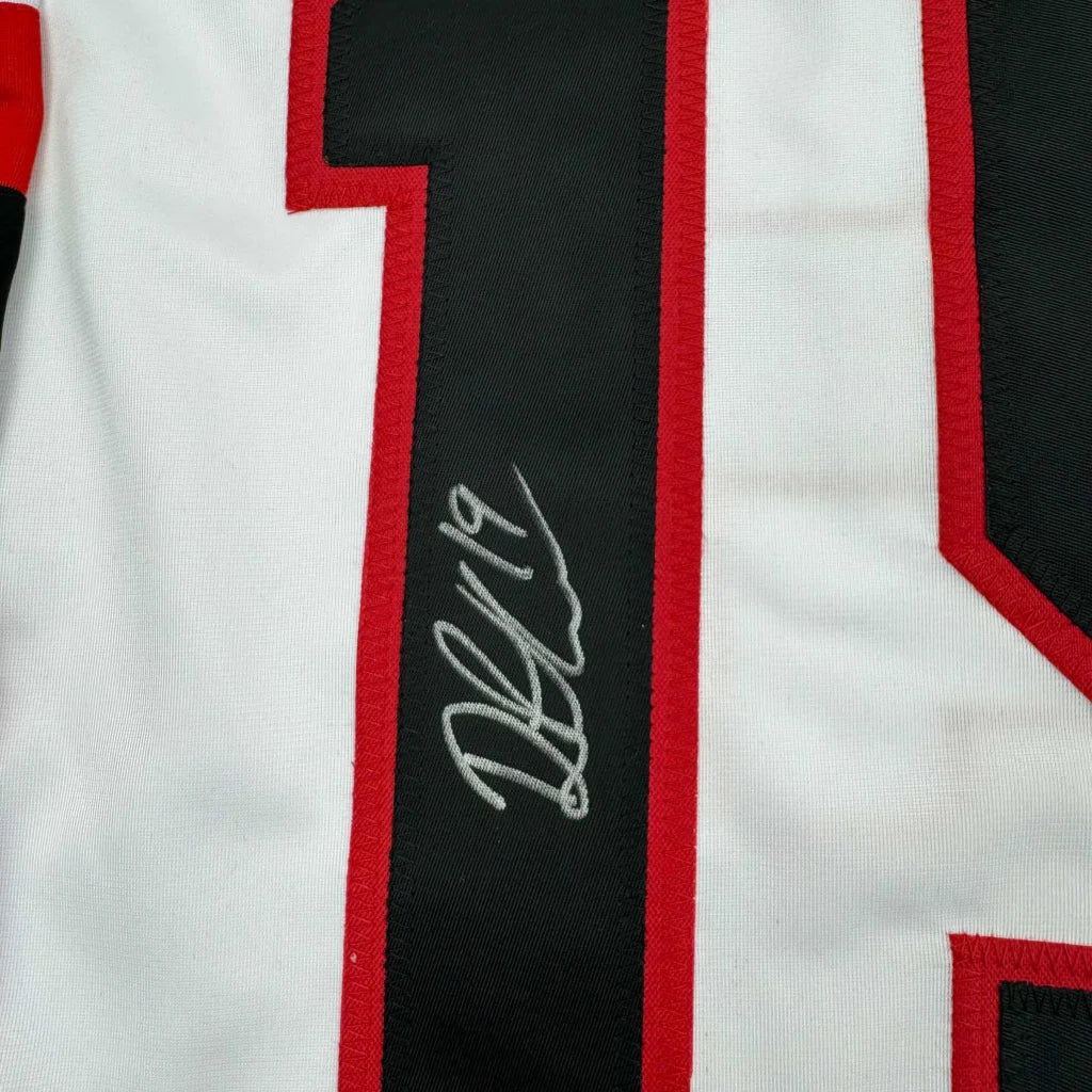 Autographed white Hockey Jersey with black and red numbers displayed in product shot