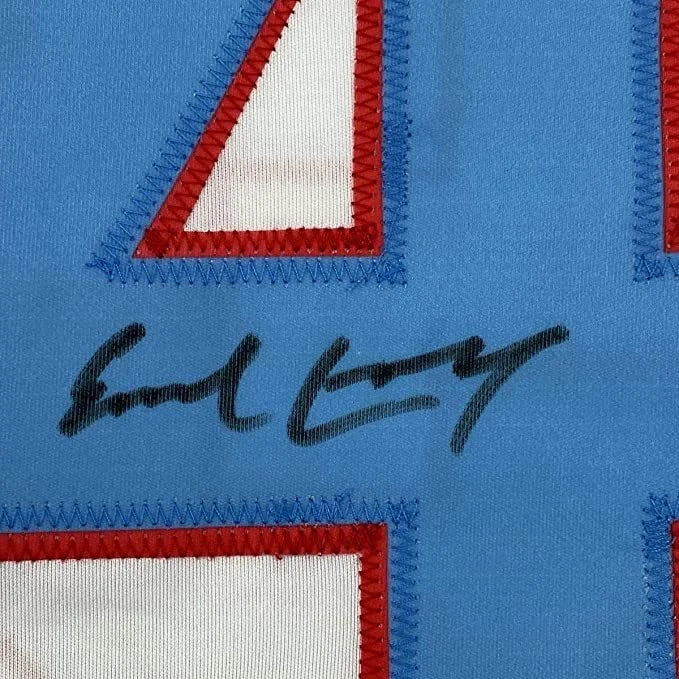 Framed autographed Earl Campbell Houston white football jersey with blue jersey, red white numerals, black signature, Beckett BAS COA
