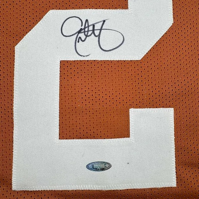 Framed autographed Eric Metcalf Texas orange jersey with white 6, black signature, JSA sticker
