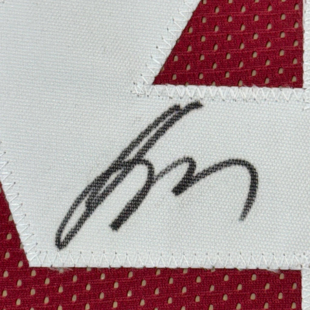 Autographed Alabama Jersey with red mesh trim ready for display