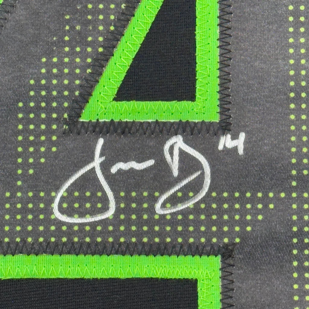 Close-up of black and neon green number 4 with white stitching on framed signed Jamie Benn Dallas hockey jersey back