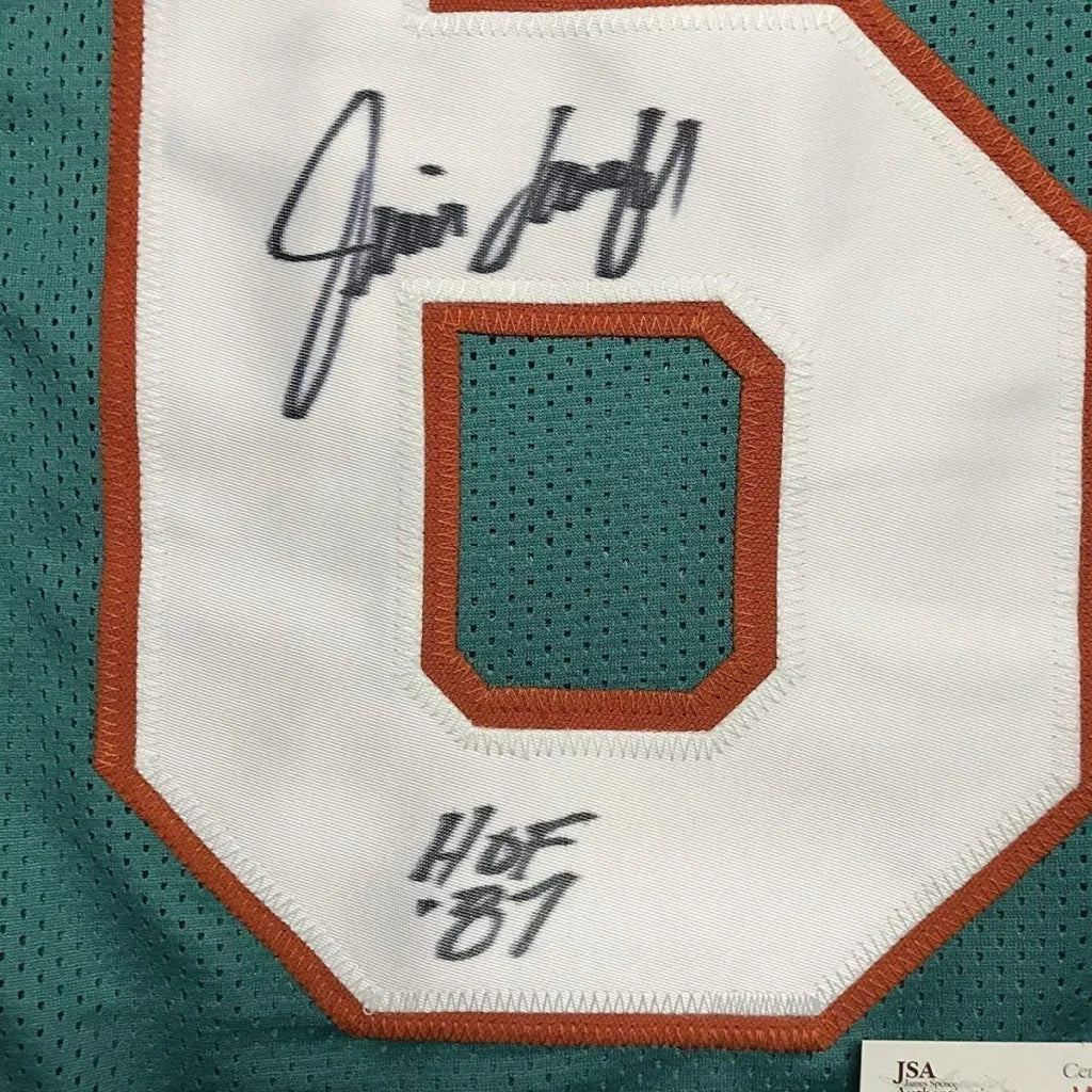 Signed Miami Dolphins jersey with Hall of Fame inscription and photos displayed