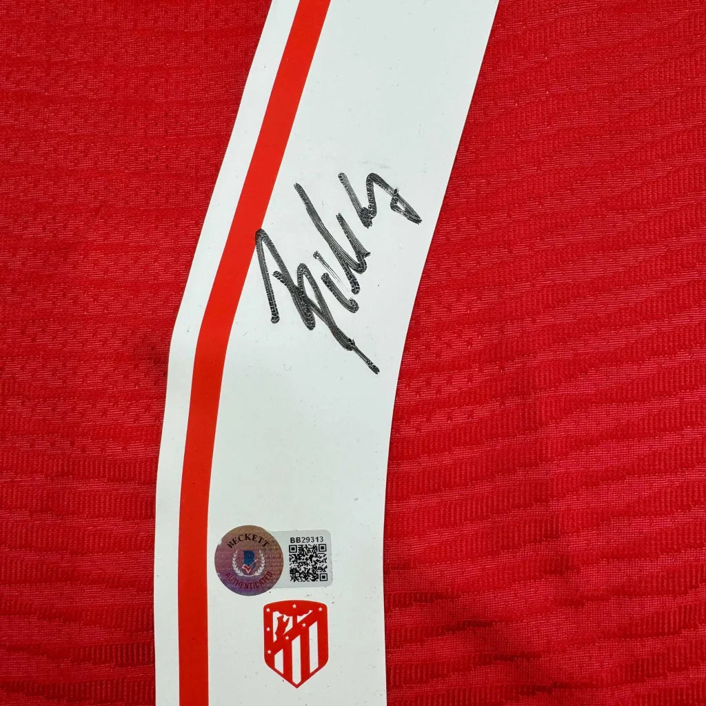 Framed autographed atletico madrid red and white striped soccer jersey with black signature and beckett authentication sticker