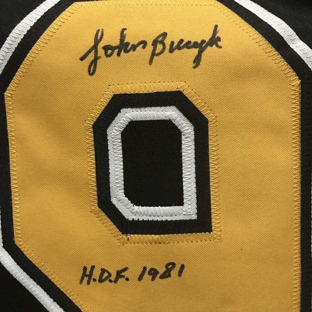 Framed autographed John Bucyk Boston Bruins black hockey jersey with yellow 0 patch