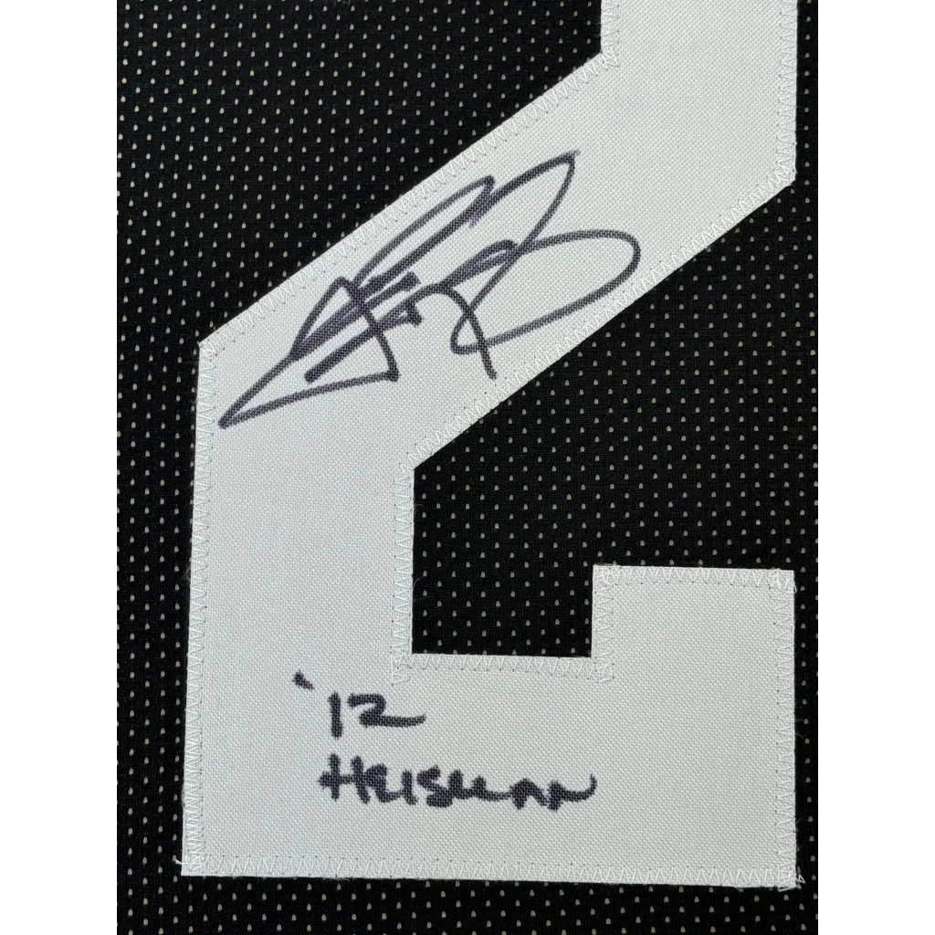 White embroidered patch with black signature and number 12 on black mesh fabric of framed autographed Johnny Manziel jersey