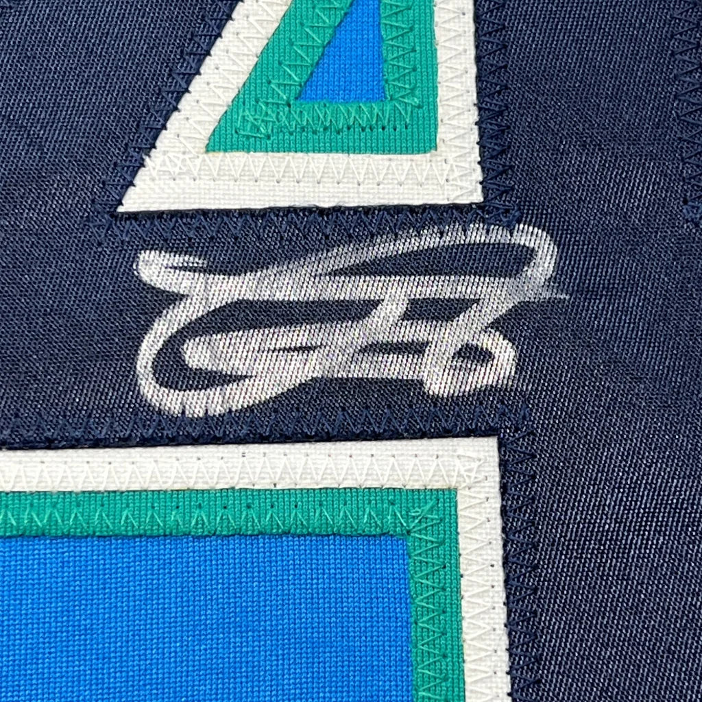 Framed autographed Julio Rodriguez Seattle Mariners light blue jersey on navy fabric with white teal geometric embroidery
