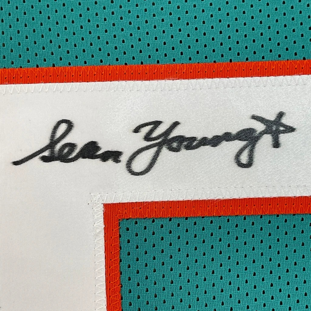 Framed autographed Sean Young Ray Finkle teal Miami Dolphins jersey with Lea Young signature label