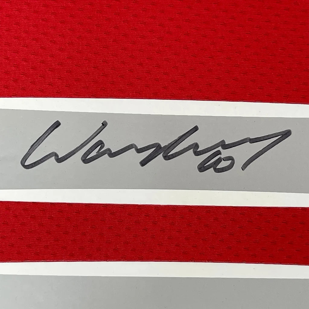 Red and gray striped fabric with a black signature from Wayne Rooney jersey