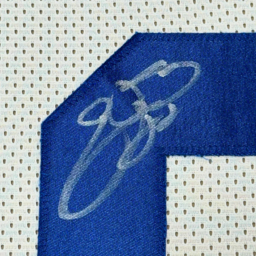 Blue Dallas Cowboys jersey with white autograph and photos in a frame
