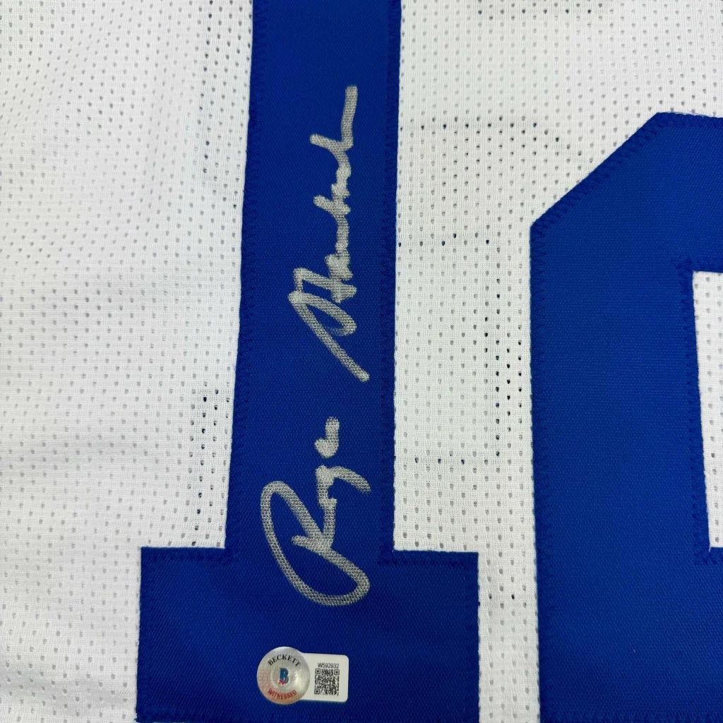 White and blue Dallas Cowboys jersey with silver Roger Staubach autograph in a frame