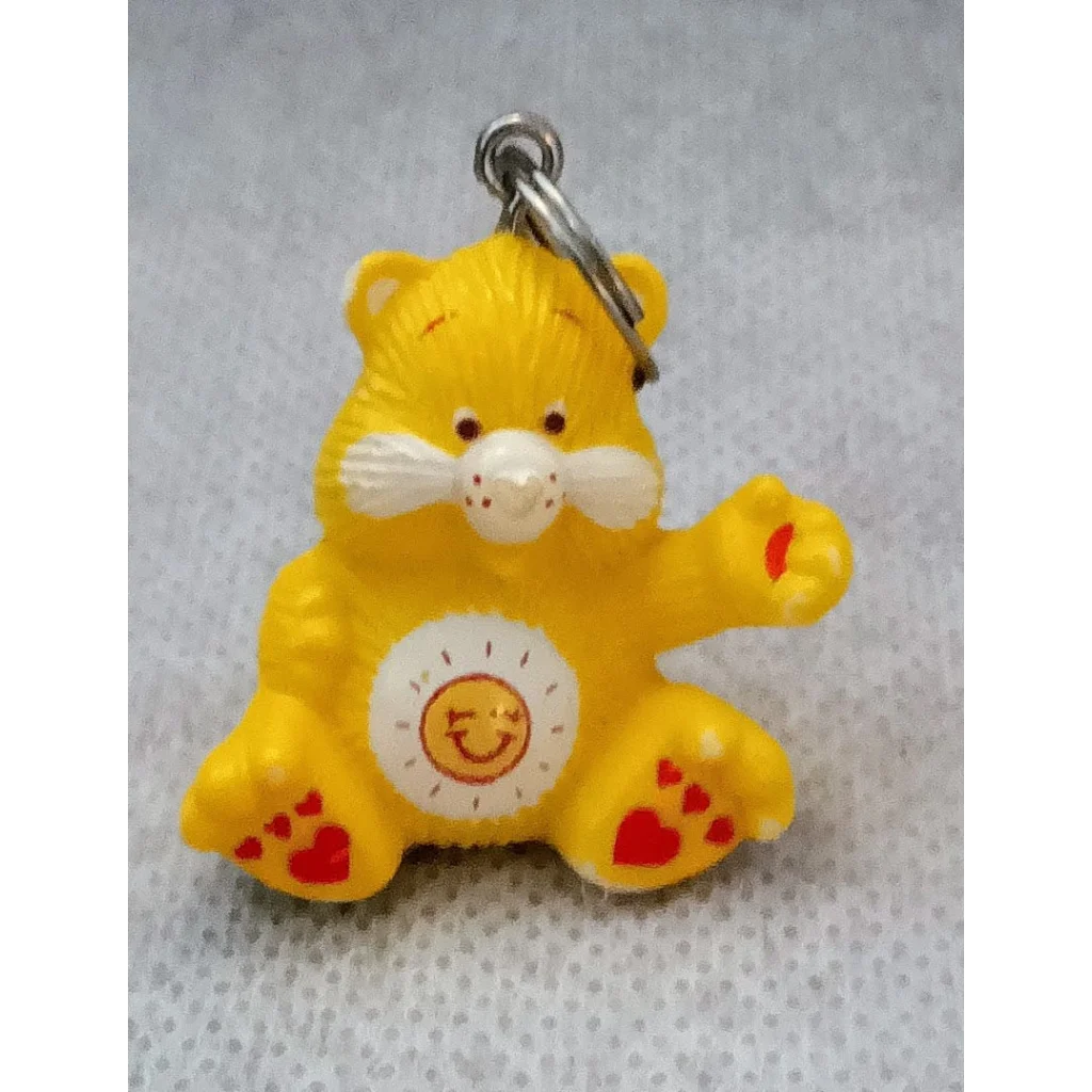 Funshine Bear Care Bears keychain charm with yellow smiling face and heart paw prints