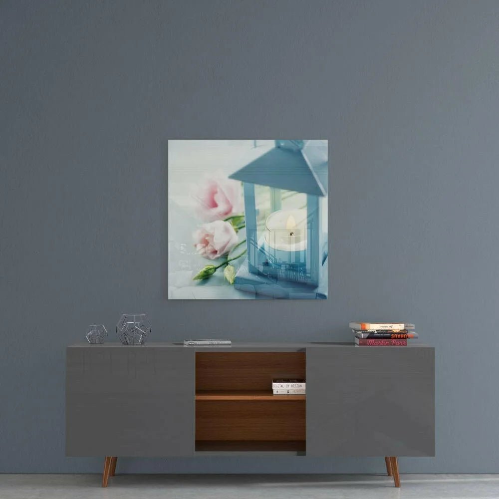 Glowing blue lantern glass wall art with lit candle and pink roses