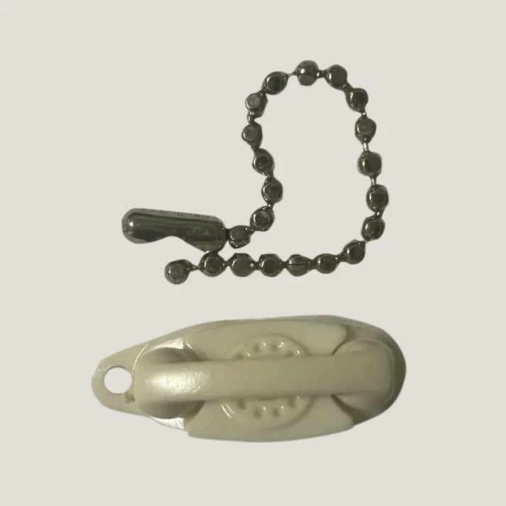 Beige nail clipper keychain with metal ball chain adds retro charm to Groovy 60s design