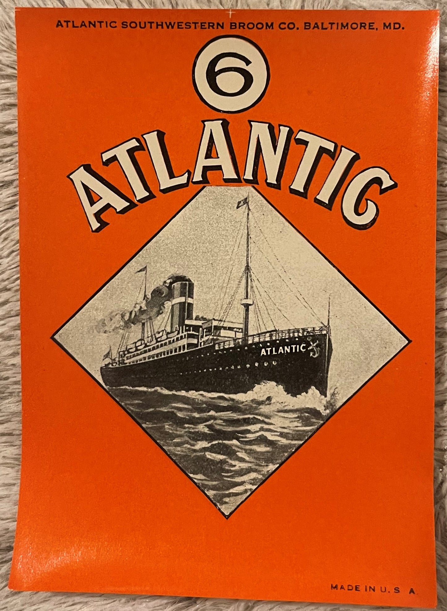 Vintage orange broom label featuring "Atlantic" text with number 6 and black-and-white illustration of steamship on diagonal
