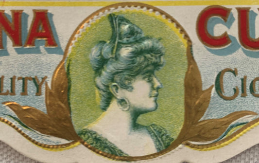 Close-up of vintage cigar box label featuring a woman's profile in an oval frame with green background, gold leaf accents, an