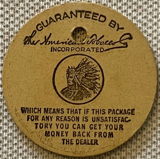 Circular tan cardboard tobacco tag with Native American chief profile and "Guaranteed by The American Tobacco Co. Incorporate