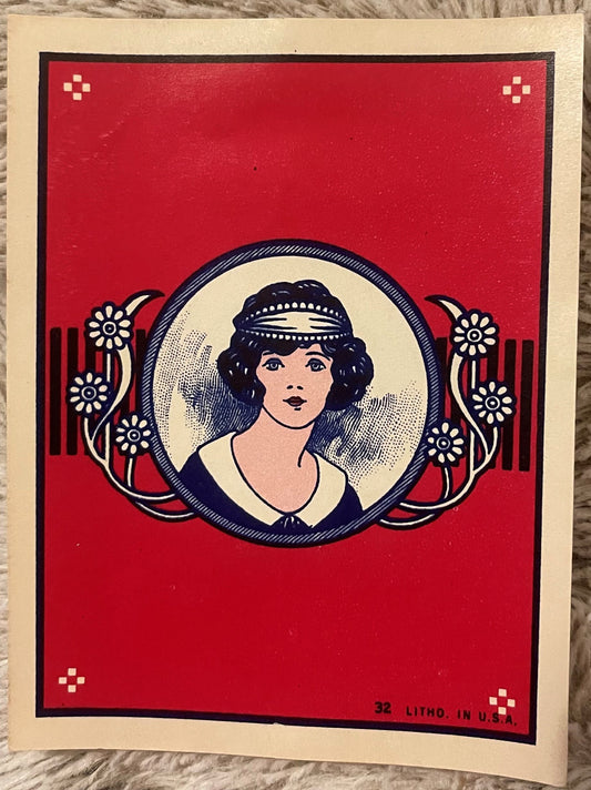 Vintage red lithograph broom label featuring a woman's portrait in circular frame surrounded by white flowers, marked "32 LIT
