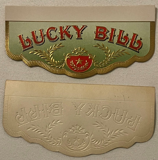 Two decorative cigar box label flaps with embossed gold borders and ornamental designs; top label shows "LUCKY BILL" in red a