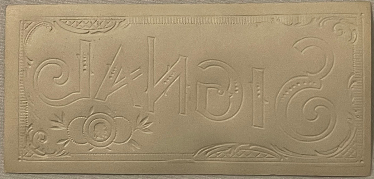 Embossed gold cigar label with "Signal" text and ornamental scrollwork borders on cream-colored paper, photographed flat.