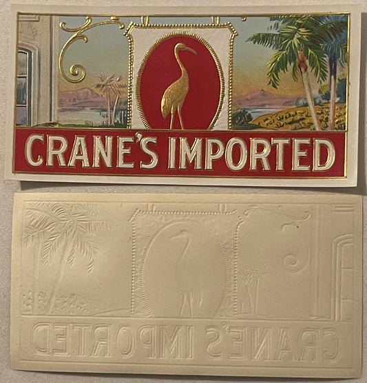 Antique Crane's Imported cigar label showing embossed golden crane on red background, displayed above cream-colored embossed