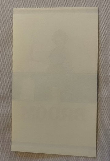 Blank cream-colored rectangular paper or label laid flat on textured gray fabric background