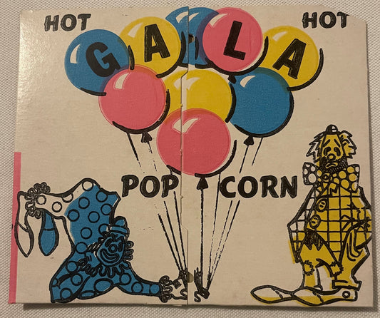 Vintage popcorn box with "HOT GALA POPCORN" text in colorful balloons, featuring blue and yellow clowns on cream background