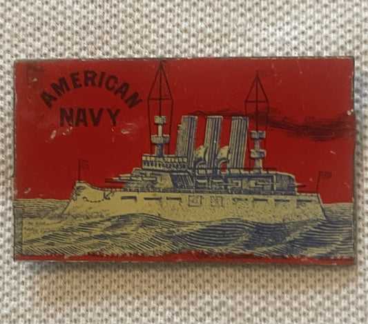 Vintage red tin tobacco tag featuring "American Navy" text and a gold battleship with three smokestacks on blue water against
