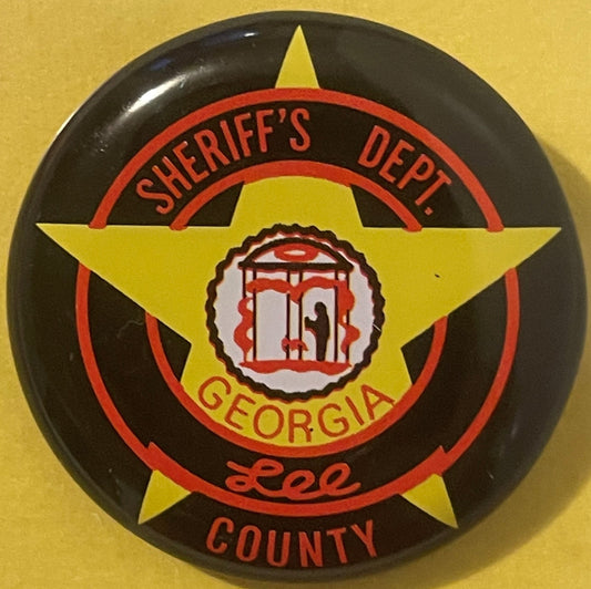 Vintage sheriff's badge pin on yellow background featuring large yellow star, red circles, and central jail building emblem w