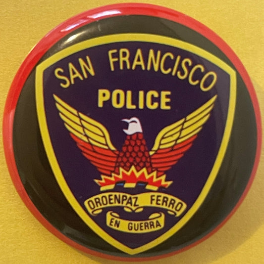 Round tin litho badge pin with red rim featuring San Francisco Police eagle emblem, yellow and navy design with Spanish motto