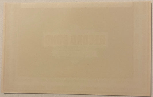 Blank cream-colored vintage cigar box label, rectangular, photographed flat against neutral background showing plain paper su