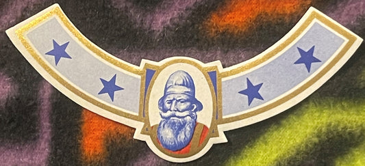 Vintage curved neck label with bearded man in helmet centered, blue stars on sides, gold trim and border on textured backgrou