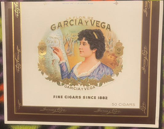 Vintage cigar box label featuring a woman in profile wearing blue dress with gold foil embossed border and text "La Flor de G
