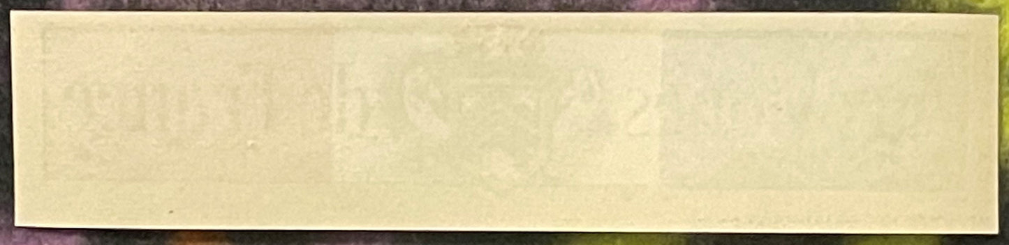 Blank cream-colored antique label with faint embossed or watermarked design, mounted on dark background