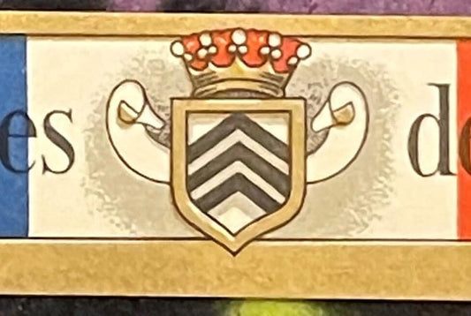 Antique wine label featuring a coat of arms with chevron shield, crown, and scrolled supporters in gold and black on cream ba