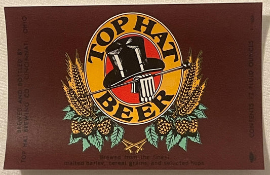 Vintage Top Hat Beer label on brown background featuring circular logo with top hat, wheat stalks, hops, and text reading "To