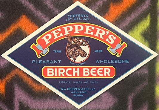 Vintage navy blue diamond-shaped Pepper's Birch Beer bottle label with red banner, moose head emblem, and cream border on col